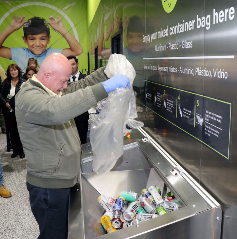 Customer emptying a mixed bag into an RCM TOMRA bulk-return machine